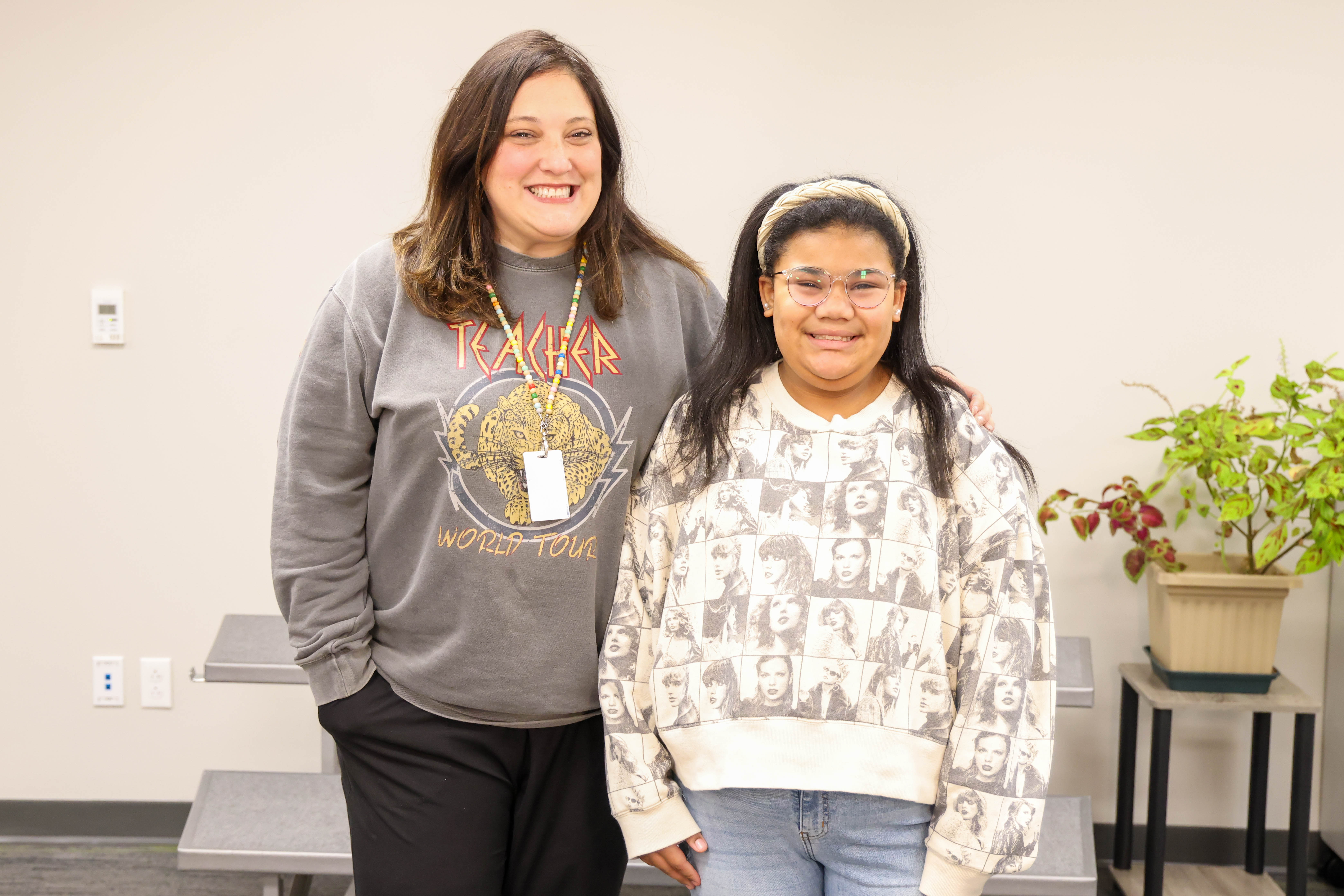 An adult and student are shown standing next to each other at a recognition program..